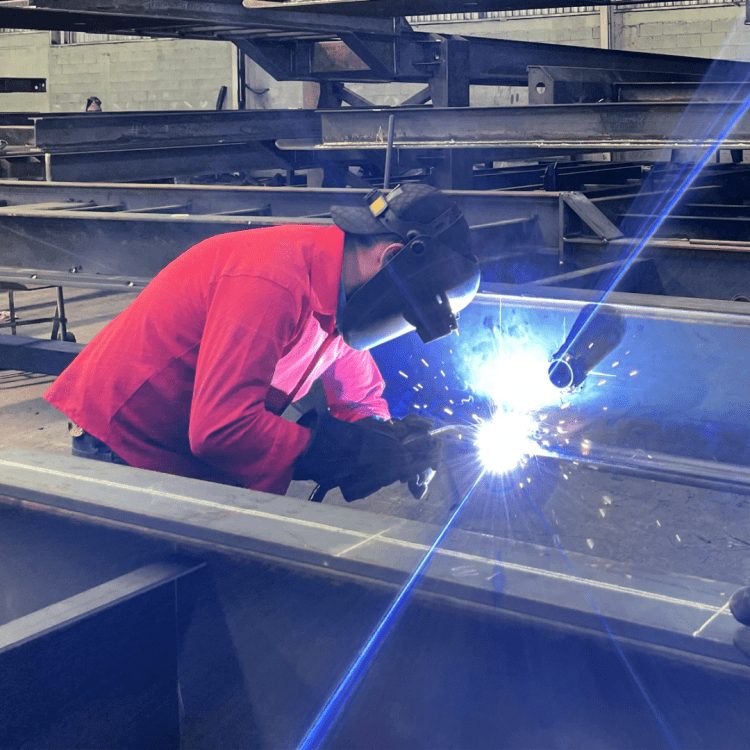 Welder fabricating a trailer frame